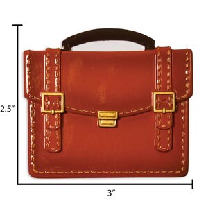 May include: A brown leather briefcase with gold buckles and stitching. The briefcase is 3 inches wide and 2.5 inches tall.