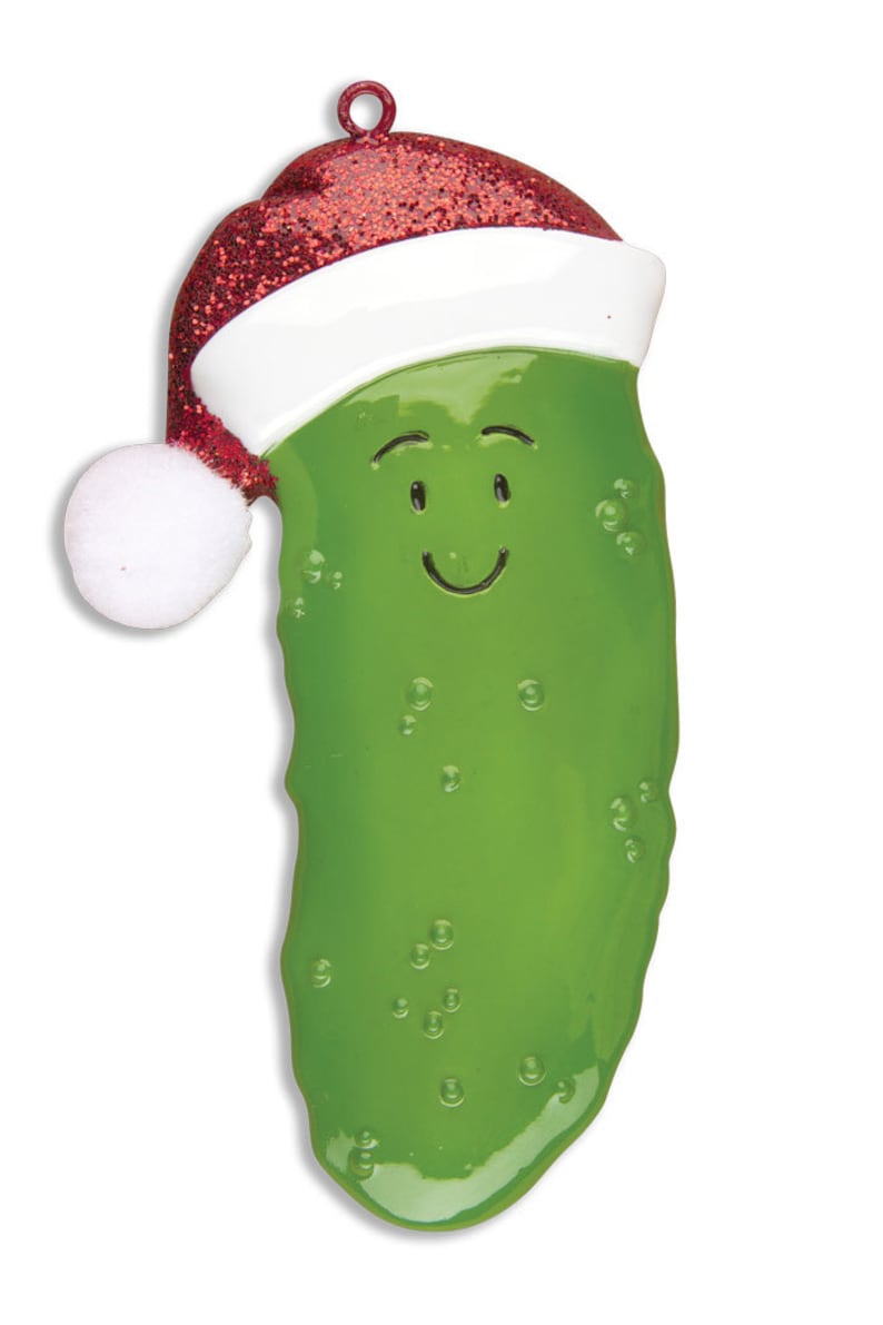Puede incluir: Un adorno de Navidad de pepinillo verde con un gorro de Pap&aacute; Noel rojo y blanco. El pepinillo tiene una cara sonriente y est&aacute; decorado con puntos blancos.