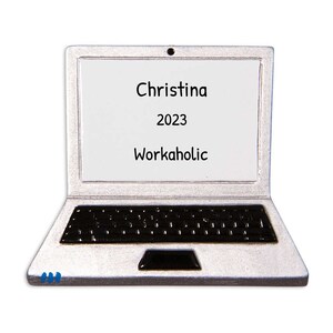 May include: A silver laptop ornament with a black keyboard and a white screen that says "Christina 2023 Workaholic".