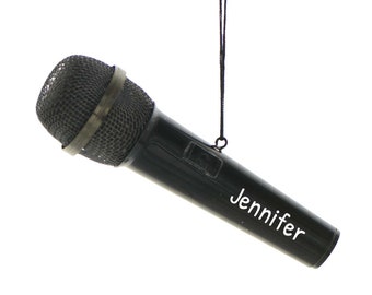 Może przedstawiać: Czarny ornament w kształcie mikrofonu z białym sznurkiem i napisem "Jennifer" na boku.