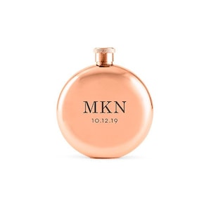 May include: A rose gold hip flask with the initials "MKN" and the date "10.12.19" engraved on the front.