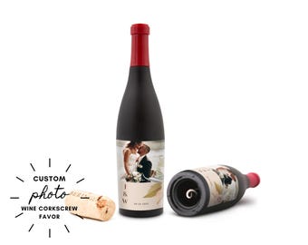 May include: Black wine bottle with a red top, featuring a custom photo of a couple. A corkscrew with a cork is next to the bottle. The text on the bottle reads "J & W" and "04.23.2023". The words "CUSTOM photo WINE CORKSCREW FAVOR" are also visible.