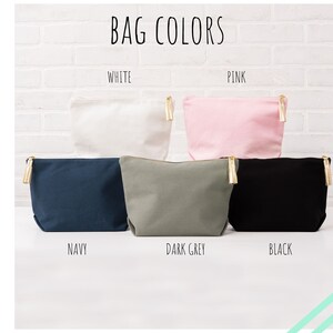 May include: Five canvas zippered pouches in different colors: white, pink, navy, dark grey, and black. Each pouch has a gold zipper pull with a tassel.
