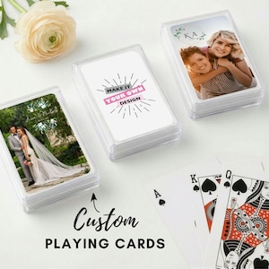 May include: Custom playing cards in clear plastic cases. One case features a wedding photo, another has a photo of two people, and a third has the text "Make it your own design". Playing cards are visible.