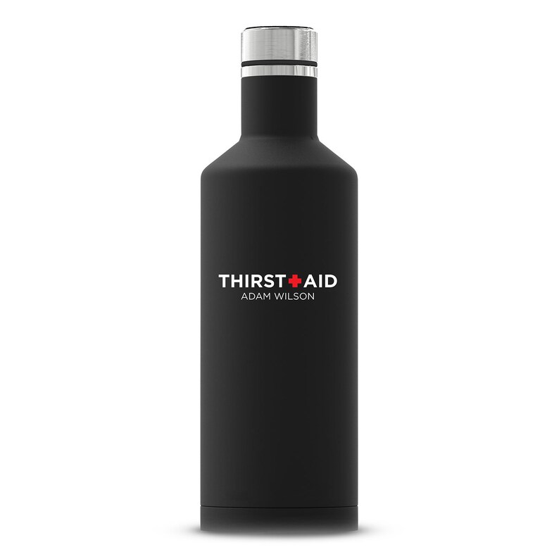 Puede incluir: Una botella de agua de acero inoxidable negra con una tapa plateada y el texto "THIRST+AID ADAM WILSON" impreso en la parte delantera.
