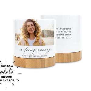 May include: White indoor plant pot with a bamboo base. One side features a photo of a woman and the text "in loving memory, forever in our hearts sis." The other side has the text "we could have you here, you'd have lived forever, xoxo."