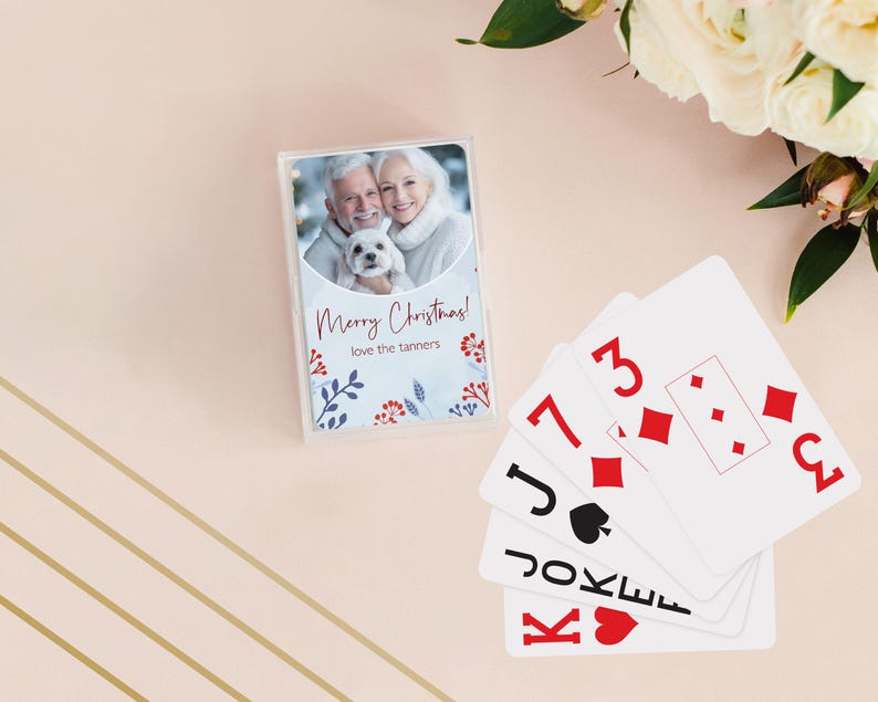 May include: A deck of playing cards with a clear plastic case featuring a photo of a smiling couple and a small white dog. The text "Merry Christmas! love the tanners" is printed on the case. Several playing cards are fanned out.