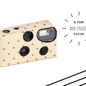 May include: A disposable camera with a gold heart pattern. The camera has a flash and is ready to use. The text on the camera reads "35mm Ready to use camera, Film & Flash is sure enough, 200 ISO Colour film".