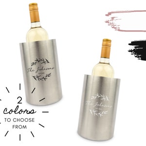 Könnte beinhalten: Ein silberner Weinkühler mit einer personalisierten Inschrift, die "The Johnsons Est. 2013" lautet, mit einem Kranz aus Blättern um den Text. Der Kühler hält eine Flasche Weißwein. Das Bild zeigt zwei verschiedene Farboptionen für die Inschrift.