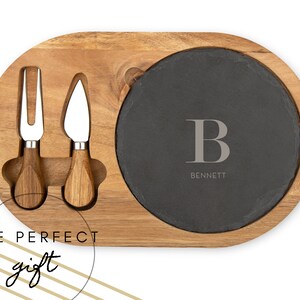 May include: A wooden cheese board with a slate serving plate and two cheese knives. The slate plate has the letter "B" and the name "BENNETT" engraved on it.