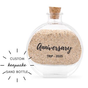 May include: A clear, round glass sand bottle with a cork stopper. The bottle is filled with sand and has the word "Anniversary" and "TRIP - 2025" printed on it. The text "CUSTOM keepsake SAND BOTTLE" is also present.