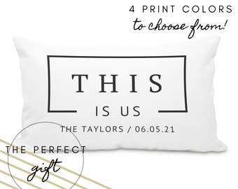 May include: White throw pillow with black text that reads "THIS IS US" and "THE TAYLORS / 06.05.21". The pillow is a personalized gift.