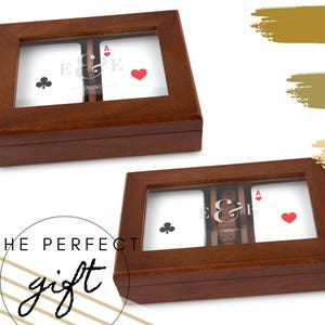 May include: Two wooden playing card boxes with glass tops. Each box displays a playing card with a club, an ace of hearts, and the initials "E & E". The text "THE PERFECT gift" is in the lower left corner.