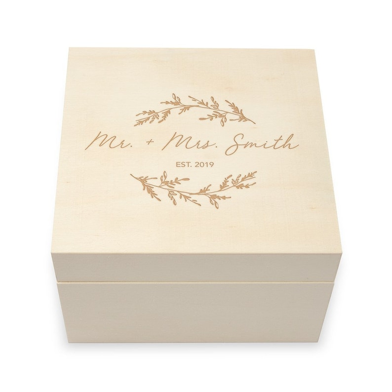 May include: A light wood box with a lid, engraved with the text "Mr. + Mrs. Smith EST. 2019" and a floral design.