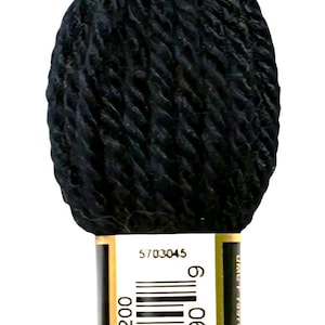 May include: A black DMC tapestry wool skein. The label reads "NOIR" and includes a barcode and the DMC logo. The yarn is tightly wound, showing the texture of the fibers. Ideal for various needlework projects.
