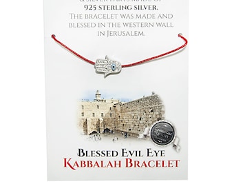 May include: Red string bracelet with a silver Hamsa hand charm with a blue evil eye. The card reads "This is to certify that this evil eye red string is hand made of original silk, and the pendant & silver parts made of 925 Sterling Silver. The bracelet was made and blessed in the Western Wall in Jerusalem. Blessed Evil Eye Kabbalah Bracelet."