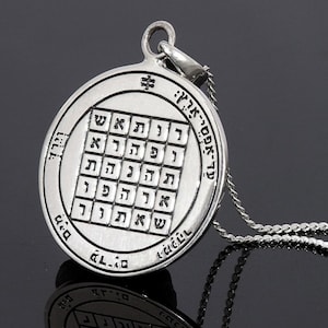 Op de afbeelding: Zilveren ketting met een ronde hanger met een Hebreeuwse inscriptie en een vierkant raster van Hebreeuwse letters. De hanger is bevestigd aan een zilveren ketting.