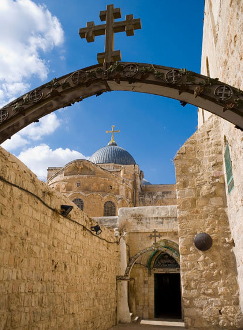 Puede incluir: Un arco de piedra con una cruz en la parte superior conduce a una vista de un edificio abovedado con una cruz en la parte superior. El edificio est&aacute; hecho de piedra y tiene una c&uacute;pula azul. El arco est&aacute; hecho de piedra y tiene un marco de madera. El arco est&aacute; decorado con tallas.