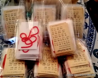 May include: Multiple clear plastic pouches containing tan cards printed with the Ben Porat Prayer in Hebrew and English text, accompanied by a length of red string. Each individual packet includes the prayer text and the website address nchen.co.il.