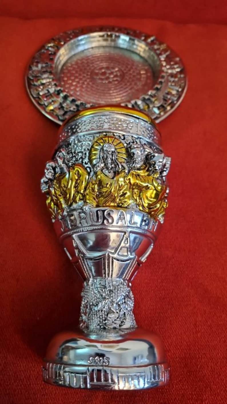 Puede incluir: C&aacute;liz de plata con detalles dorados y elaborados. El c&aacute;liz presenta una representaci&oacute;n de Jesucristo y las palabras "Jerusal&eacute;n" y "925".