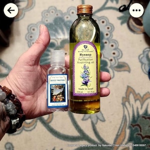 May include: Two glass bottles, one clear and one amber, with labels. The clear bottle is labeled "Holy Water" and the amber bottle is labeled "Ein Gedi Hyssop Purification Anointing Oil". Both bottles are 250 ml. and made in Israel.