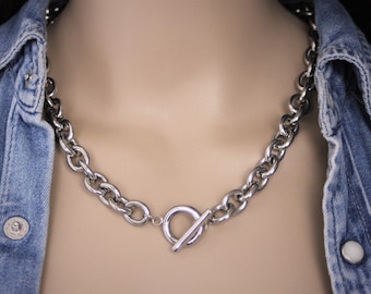 May include: A silver chain necklace with a large, chunky link design and a toggle clasp.