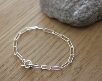 Bracciale in argento sterling con maglie a catena rettangolari di grandi dimensioni e chiusura a moschettone.