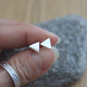 Op de afbeelding: Een paar zilveren driehoekige oorbel studs. De oorbellen zijn klein en eenvoudig en perfect voor dagelijks gebruik.