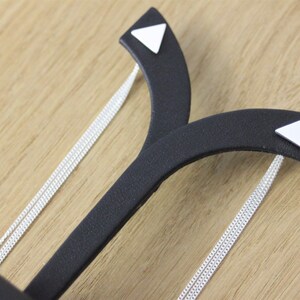 May include: Two silver chains on a black display stand with white triangle accents.