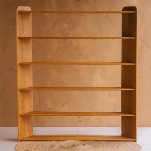May include: A tall, light-colored wooden bookshelf with six shelves. The bookshelf has a simple, modern design with rounded edges and a natural wood grain finish. The shelves are evenly spaced and appear sturdy.