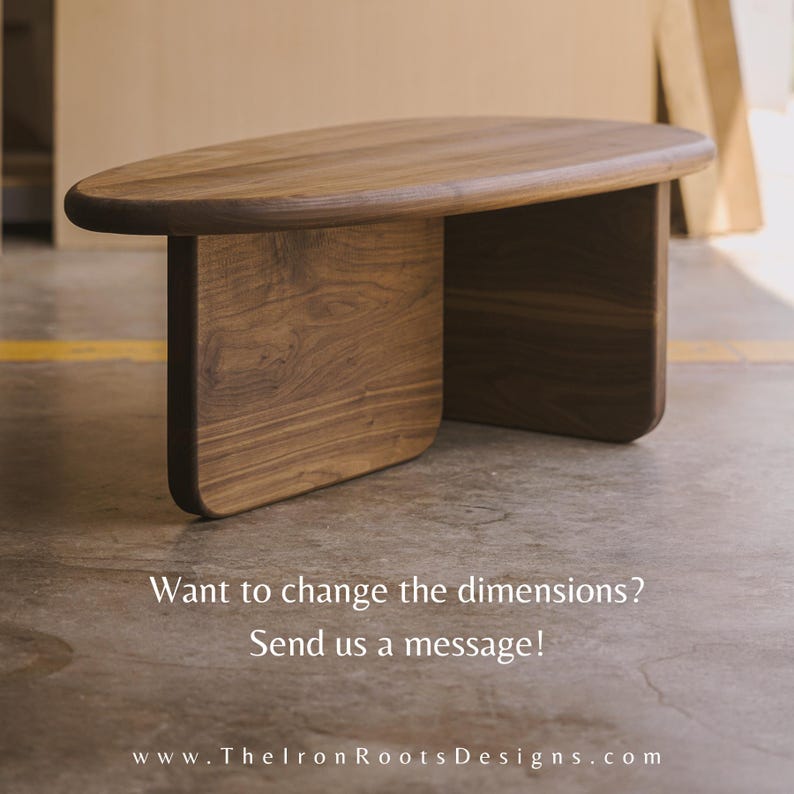 May include: A wooden coffee table with a smooth, oval top and two rectangular legs. The table is made of dark brown wood with visible grain. Text on the image reads: "Want to change the dimensions? Send us a message!"