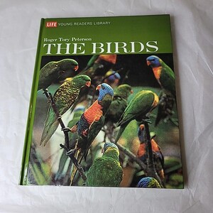 Puede incluir: Un libro de tapa dura titulado "THE BIRDS" de Roger Tory Peterson. La portada presenta una imagen vibrante de varios pájaros coloridos posados en ramas. El libro forma parte de la serie "LIFE Young Readers Library".