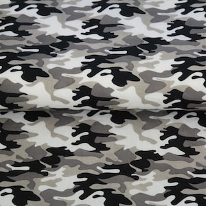 Könnte beinhalten: Tarnstoff in den Farben Schwarz, Grau und Weiß. Der Stoff hat ein sich wiederholendes Muster aus unregelmäßigen Formen.