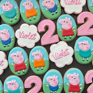 May include: A collection of decorated sugar cookies featuring characters from the children's cartoon show Peppa Pig. The cookies are decorated with pink, blue, green, orange, and white icing. Some cookies feature the number "2" and the name "Violet".