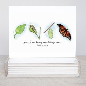 May include: A white card with a watercolor illustration of a butterfly life cycle. The illustration shows a green leaf, a caterpillar, a chrysalis, and a butterfly. The card has the text "See, I am doing something new! Isaiah 43:18-19".