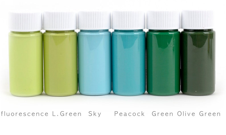 May include: Six small paint bottles with white lids, showcasing a spectrum of colors from light green to dark olive green. The labels read: fluorescence L.Green, Sky, Peacock, Green, and Olive Green.