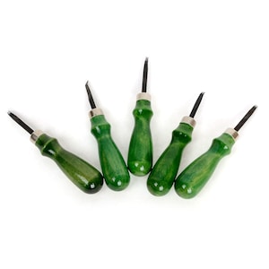 Può includere: Cinque strumenti per la lavorazione della pelle con manici verdi e lame nere sono disposti su sfondo bianco. I manici sono di un verde medio lucido e le lame sono sottili e appuntite. Ogni strumento ha un collare in metallo argentato.