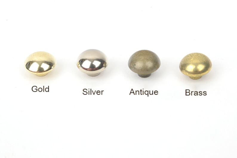 May include: Four mushroom-shaped cabinet knobs in gold, silver, antique, and brass finishes. Each knob is labeled with its respective finish color. These knobs are suitable for furniture restoration or new builds.