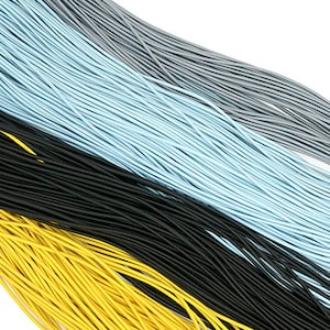 May include: A collection of colorful cords in yellow, black, light blue, gray, and white. The cords are thin and appear to be made of a flexible material, possibly for crafting or jewelry making. The cords are arranged diagonally.