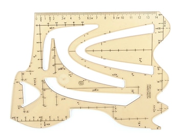 May include: A transparent beige drafting tool with various cut-out shapes and measurement markings. The tool features a ruler edge with inch measurements and mathematical notations, including sin x and 2x2. The brand name KOH-I-NOOR HARDTMUTH is printed on the side.