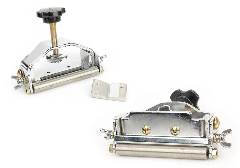 K&ouml;nnte beinhalten: Zwei Metallkantenschneider mit schwarzen Kn&ouml;pfen und silberner Hardware. Ein Trimmer hat eine Schraube zur Einstellung, der andere Fl&uuml;gelmuttern. Ein kleines silbernes Metallteil ist ebenfalls enthalten.