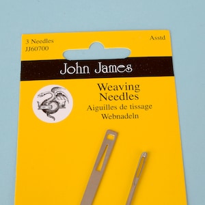 May include: A package of John James weaving needles on a yellow background. The package includes three needles and the text "Weaving Needles" in English, French, and German. The package also has a circular illustration of a dragon.