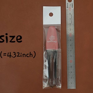 K&ouml;nnte beinhalten: Ein rosa Kosmetikpinsel mit dem Text "SJC SAMJOUNG" in einer transparenten Plastikverpackung. Die Gr&ouml;&szlig;e betr&auml;gt 11 cm. Ein Metalllineal befindet sich neben dem Pinsel.