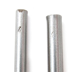May include: Two silver metal rods, each marked with the number '4'. The rods are cylindrical and have a slightly textured surface. The background is plain white.