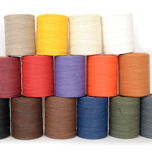 May include: A collection of spools of twine in various colors, including beige, yellow, cream, white, burgundy, red, purple, orange, and brown. Additional colors are black, dark brown, medium brown, navy blue, olive green, and gray.