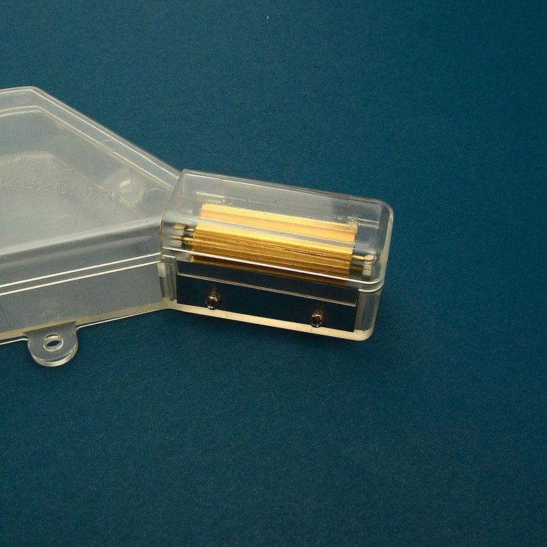 Puede incluir: Un sacapuntas de pl&aacute;stico transparente con un compartimento rectangular de cuchillas doradas. El sacapuntas tiene una tapa de pl&aacute;stico transparente y una base azul oscuro.