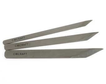 May include: Three gray metal craft tools with angled tips are arranged on a white background. Each tool has the text "CM CRAFT" printed on it. The tools appear to be for shaping or cutting materials.