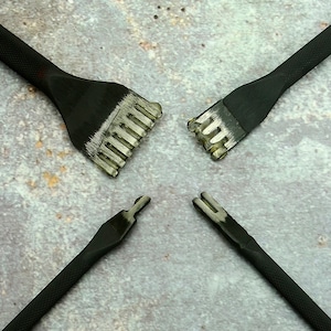 Puede incluir: Cuatro herramientas negras para trabajar el cuero, con mangos texturizados y cabezas ranuradas plateadas, dispuestas en círculo. Estas herramientas están diseñadas para dar forma y detallar el cuero, comúnmente usadas en artesanía.