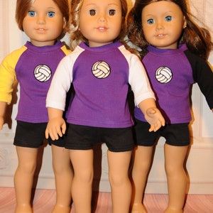 Puede incluir: Tres mu&ntilde;ecas de piel clara y ojos azules o marrones, cada una con una camiseta morada con un gr&aacute;fico de voleibol blanco en el pecho y pantalones cortos negros. Las camisetas tienen mangas tres cuartos de color amarillo, blanco y negro.