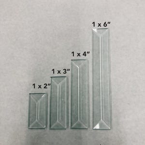 May include: Four clear glass rectangular tiles of varying sizes are arranged vertically. The sizes are labeled: 1 x 2", 1 x 3", 1 x 4", and 1 x 6". Each tile has a beveled edge design.